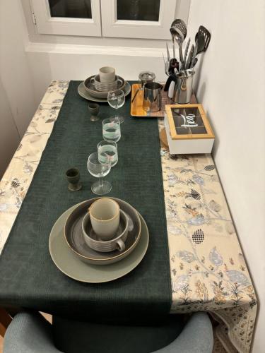 une table avec des assiettes et des verres à vin dessus dans l'établissement Fleur de sel studio, à Tarascon