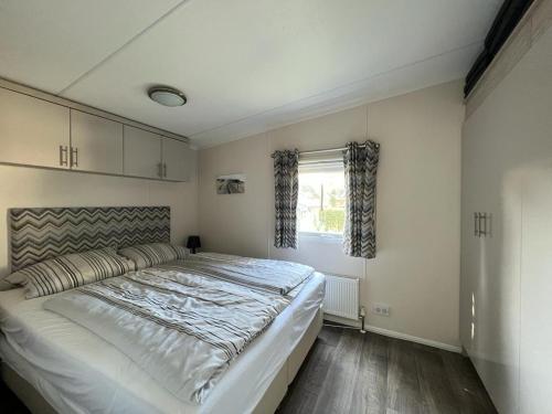 - une chambre avec un grand lit et une fenêtre dans l'établissement Chalet am See, à Lathum