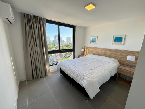 1 dormitorio con cama y ventana grande en View Luxury en Punta del Este