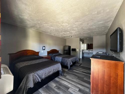 Sunpark Inn & Suites في سان برناردينو: غرفة فندقية بسريرين وتلفزيون بشاشة مسطحة