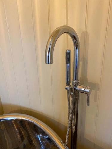 a shower with a faucet in a bathroom at Ham Hideaway Boutique Glampsite in Kent