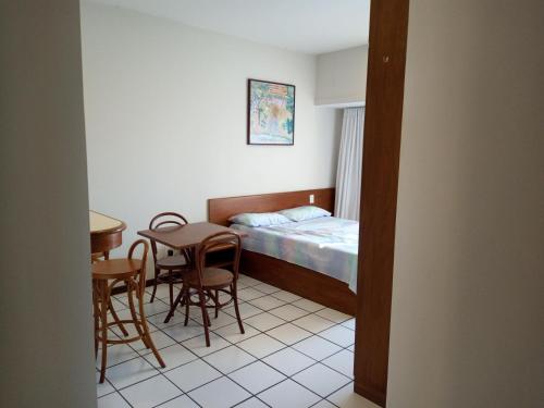 薩爾瓦多的住宿－Studio Vista ao Mar，小房间设有一张床、一张桌子和椅子