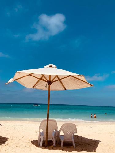 two chairs under an umbrella on the beach at ROCHA BEACH CLUB in Barú
