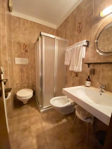a bathroom with a toilet and a sink and a shower at Affittacamere Garden Cavalese in Cavalese