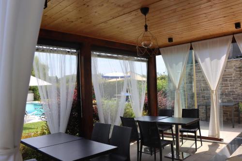 a dining room with a table and chairs and windows at Il Toscanello in Lido di Camaiore