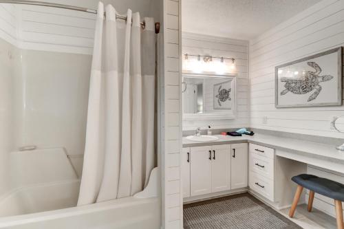a white bathroom with a tub and a sink at 3009 Cameron in Isle of Palms