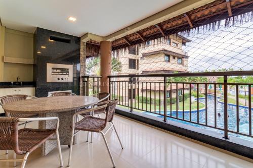 d'un balcon avec une table, des chaises et une grande fenêtre. dans l'établissement Manhattan Beach Riviera, à Aquiraz