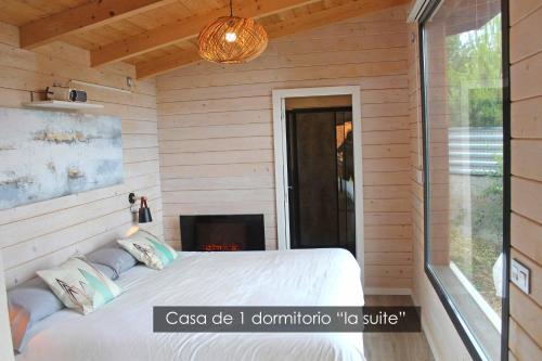 ein Schlafzimmer mit einem Bett und einem Kamin in der Unterkunft NidoGredos Cabañas Ecológicas de Diseño in El Tiemblo