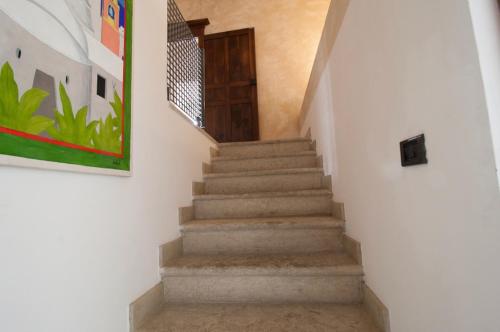 een trap in een huis met een schilderij bij Diaz8 di TSS' - Nel cuore di Trento - Spazioso ed elegante - Silenzioso - Perfetto per smartworking in Trento