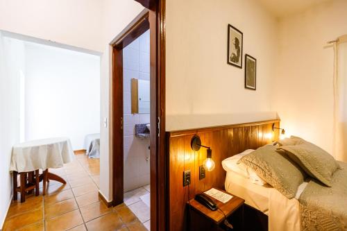 a small bedroom with a bed and a bathroom at Hotel Morro De Santo Agostinho in Serra Negra