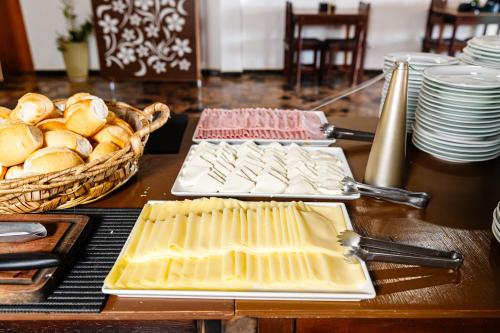 a table with cheese and bread and plates on it at Hotel Morro De Santo Agostinho in Serra Negra