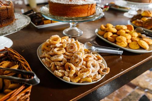 a table topped with plates of pretzels and cakes at Hotel Morro De Santo Agostinho in Serra Negra