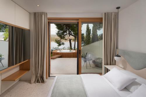 a bedroom with a bed and a balcony with a tub at Villa Liore in Marina