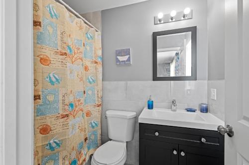 a bathroom with a toilet and a sink and a mirror at FaithInn - 3 Bed 2 Bath Near EWR/ Downtown/ NYC in Newark