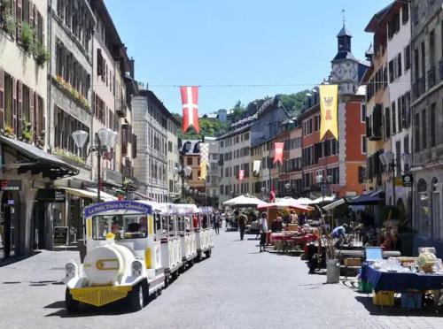 une rue de la ville avec un train dans la rue dans l'établissement Appartement spacieux / T2 refais à neuf / proche centre, à Chambéry