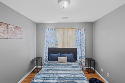 - une chambre avec un lit doté de draps bleus et une fenêtre dans l'établissement FaithInn - 3 Bed 2 Bath Near EWR/ Downtown/ NYC, à Newark