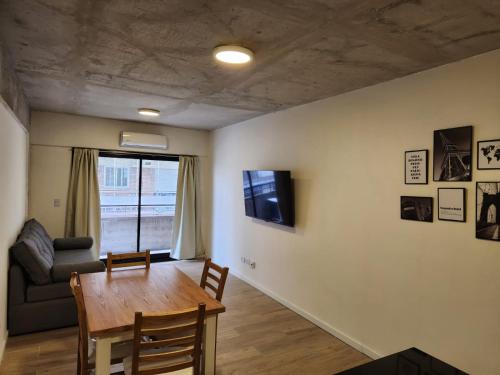 sala de estar con mesa y sofá en Tranquilo Apart en Palermo 2 ambientes en Buenos Aires