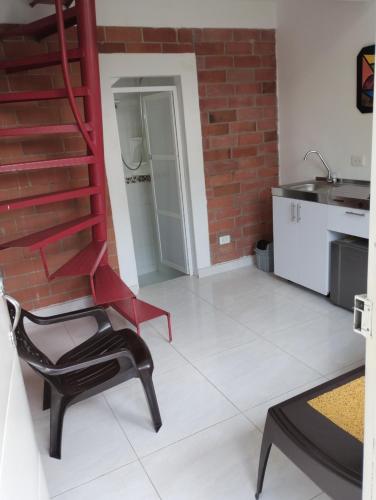 een woonkamer met een stoel en een bakstenen muur bij A diez minutos del aeropuerto in Palmira