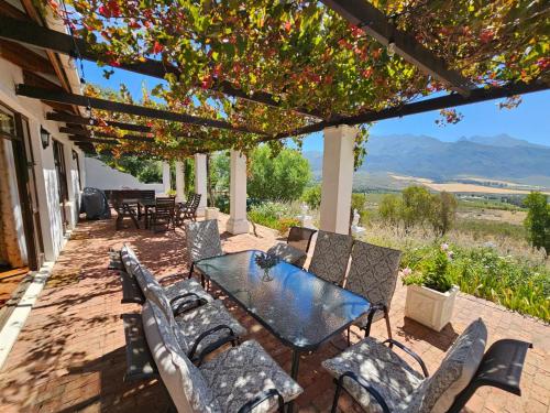 a table and chairs on a patio with a view at Valley View Eco Country Estate - Paradise in the Winelands in Villiersdorp