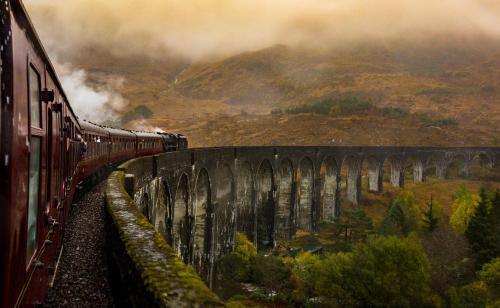 a train on a bridge over a mountain at The Crossing in Kingussie