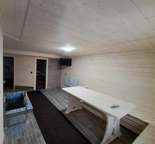 Zimmer mit einem weißen Tisch in einem Zimmer in der Unterkunft Садиба у Курила з сауною та чаном на дровах in Shepot