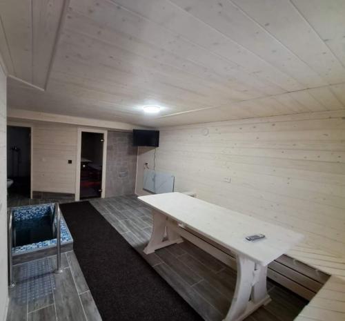a room with a white table in a room at Садиба у Курила з сауною та чаном на дровах in Shepot