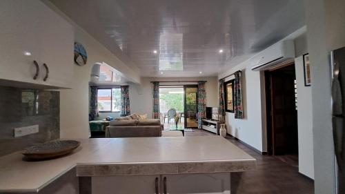 a kitchen and living room with a table and a couch at TAHITI - Teakavehere Pool in Pirae