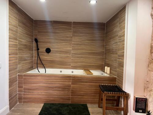 a bath tub in a room with wooden walls at Prince of Beer Sheva by CROWN in Beer Sheva