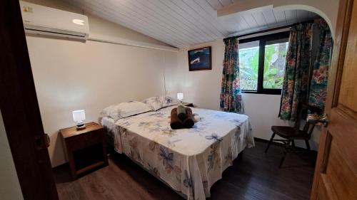 a bedroom with a bed with a teddy bear sitting on it at TAHITI - Teakavehere Pool in Pirae