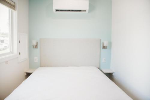 uma cama branca num quarto com uma janela em Sun Outdoors Cape Charles em Cape Charles