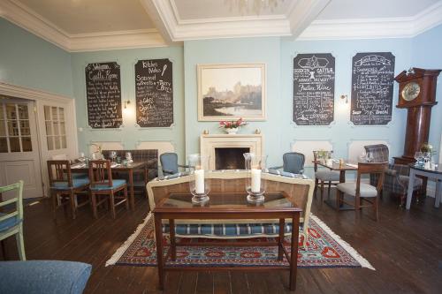 a restaurant with tables and chairs and a fireplace at Norfolk Arms Hotel in Arundel
