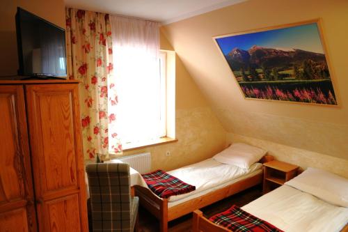 ビャウィ・ドゥナイェツにあるDom Wczasowy Dunajecのベッド2台と窓が備わるホテルルームです。