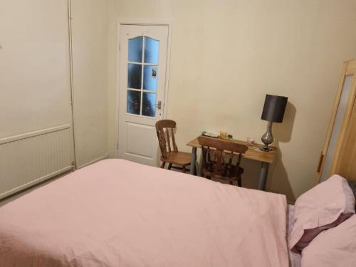 um quarto com uma cama, uma secretária e uma janela em Excellent stay em Leicester
