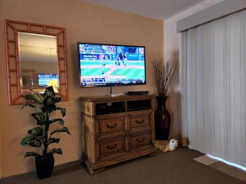 a living room with a flat screen tv on a wooden dresser at 107 - 2/2 Poolside in Edgewater