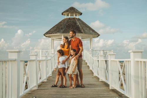 a family standing on a pier on a boardwalk at Hyatt Ziva Rose Hall - All Inclusive in Montego Bay