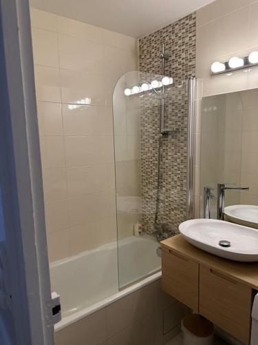 a bathroom with a shower and a sink and a tub at Appartement refait à neuf au pied de paris Paris in Saint-Ouen