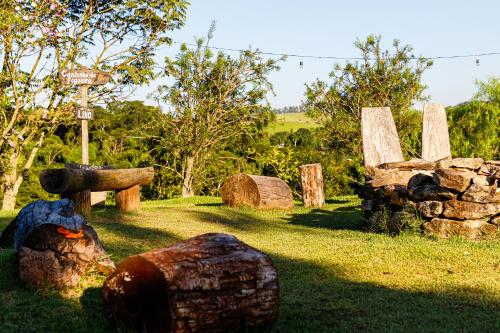 a group of wooden logs sitting in the grass at Hotel Morro De Santo Agostinho in Serra Negra