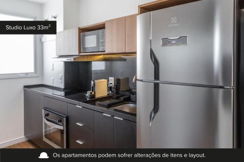 a kitchen with a stainless steel refrigerator at Charlie Connect PUC in Porto Alegre