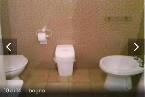 a bathroom with a white toilet and a sink at Condominio Smeraldo in Torre Forte