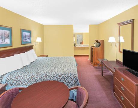 a hotel room with a bed and a flat screen tv at Travel Inn North Little Rock in North Little Rock