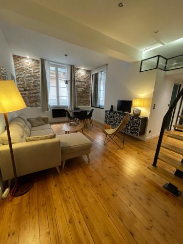 un salon avec un canapé et une table dans l'établissement Cosy Fourbastard, à Toulouse