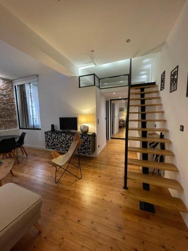 a living room with a spiral staircase in a house at Cosy Fourbastard in Toulouse