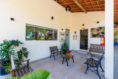 a patio with benches and a table and chairs at Hotel Morro De Santo Agostinho in Serra Negra