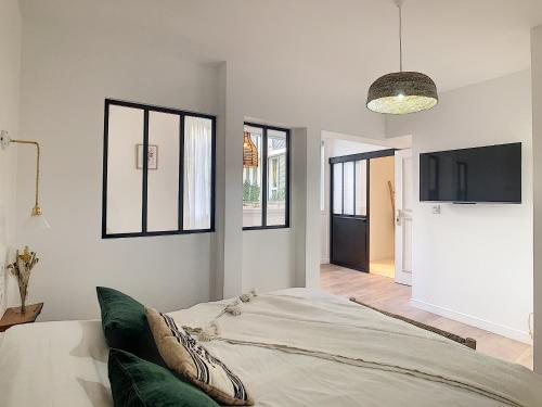 une chambre avec un lit et une télévision à écran plat dans l'établissement - - - Maison ŪMA - - - Wifi, Mer et Centre, à Marseille