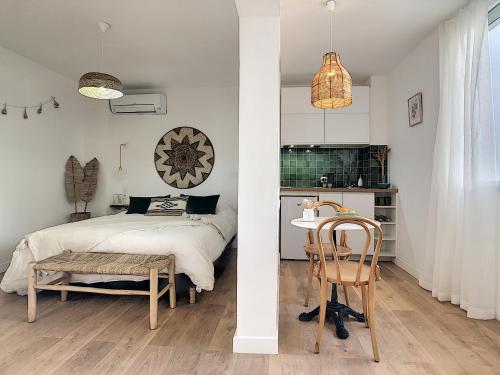 une chambre avec un lit et une table avec une chaise dans l'établissement - - - Maison ŪMA - - - Wifi, Mer et Centre, à Marseille