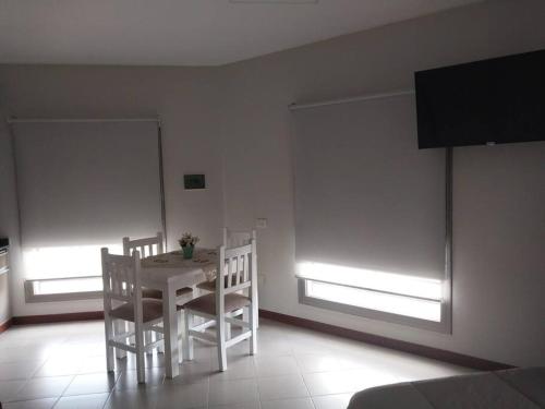 una mesa blanca y sillas en una habitación con ventanas en Monoambiente en zona centrica con garage en Concordia