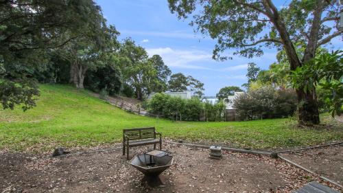 a bench sitting in a park next to a tree at Lakeview Treehouse in Metung