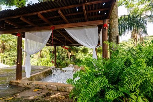 a patio with a table and chairs under a pergola at Hotel Morro De Santo Agostinho in Serra Negra