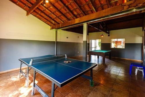 a ping pong table in a room with two tables at Hotel Morro De Santo Agostinho in Serra Negra