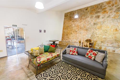 a living room with a couch and a chair at Hotel Morro De Santo Agostinho in Serra Negra